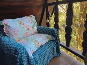 欧鲁普雷图Chalé Floresta Amada的凉椅,带枕头,位于门廊上