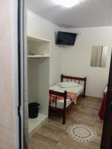佩尼亚Pousada Pontal da Armação的小房间设有床铺和电视