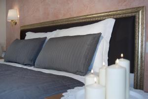 罗马天堂旅馆的一张带两个枕头的床和金框镜子