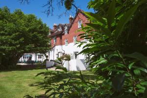 伯利Moorhill House Bed & Breakfast的一座红砖大房子前面有树木