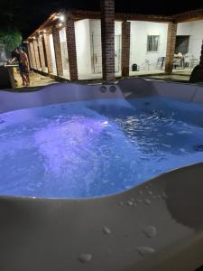 伊塔马拉卡Casa com piscina em Itamaracá的热水浴池在晚上装满蓝色的水