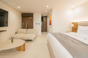 西归浦市Haeilri Pool&SPA Hotel的酒店客房设有床和客厅。