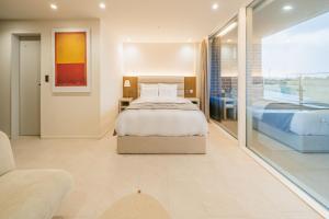 西归浦市Haeilri Pool&SPA Hotel的一间卧室设有一张床和一个大窗户