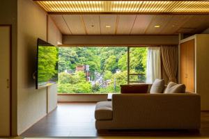 箱根Hakone Yumoto Onsen Hotel Kajikaso的带沙发和大窗户的客厅