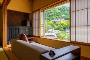 箱根Hakone Yumoto Onsen Hotel Kajikaso的带沙发和大窗户的客厅