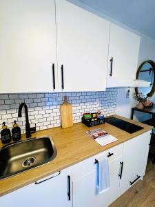 梅尔顿Stylish tiny home in Melton west的厨房配有白色橱柜和水槽