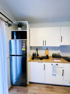 梅尔顿Stylish tiny home in Melton west的厨房配有蓝色冰箱和白色橱柜
