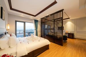 会安Eco Lux Riverside Hotel & Spa的一间带大床的卧室和一个阳台