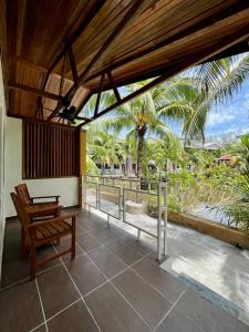 珍南海滩Airis Sanctuary Resort的一个带长凳的门廊和一个带棕榈树的阳台