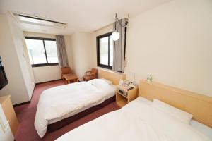 奄美安美港大厦酒店的一间酒店客房,设有两张床和电视