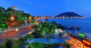 头顿OrangeBlue villa near Beach Pool free Vung Tau Vietnam的夜晚的城市景观与水景