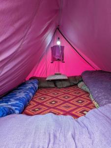 KedārnāthKedar Tent House的粉红色的帐篷,里面配有一张床