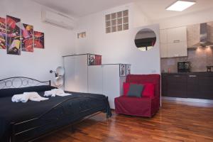 卡利亚里Visit Cagliari的一间卧室配有一张床和一张红色椅子