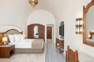 沙姆沙伊赫Movenpick Resort Sharm El Sheikh的一间酒店客房,配有一张床和一台电视