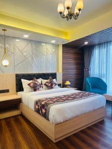 大吉岭Hotel Broadway Boutique Mall Road Darjeeling - A Luxury Collection - Best Seller的一间卧室配有一张大床和一张蓝色椅子