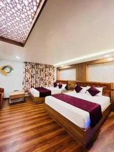 大吉岭Hotel Broadway Boutique Mall Road Darjeeling - A Luxury Collection - Best Seller的铺有木地板的客房内的两张床