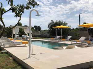 斯佩基亚B&B Casa Karina Pool&Rooms的一个带躺椅和遮阳伞的游泳池