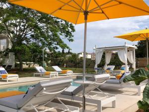 斯佩基亚B&B Casa Karina Pool&Rooms的一组椅子和遮阳伞,位于游泳池旁