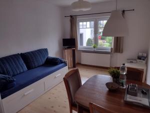 NauortFerienwohnung mit Herz的客厅配有蓝色的沙发和桌子