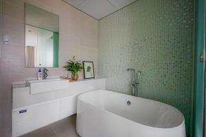 胡志明市滨城城市之夜公寓的带浴缸的浴室和绿色瓷砖墙