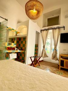 波西塔诺玛利亚别墅套房旅馆的客房设有床、电视和窗户。