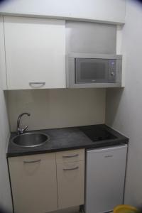 罗萨斯Aparthotel Els Molins的一间带水槽和微波炉的小厨房