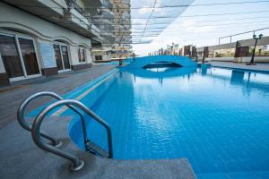 亚历山大AIFU Hotel El Montazah Alexandria的大楼前的大型蓝色游泳池