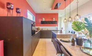 DalhemMaison de vacances的厨房设有橙色墙壁和桌椅