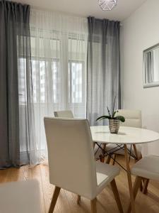 萨格勒布Ocean Apartment的白色的用餐室配有桌椅