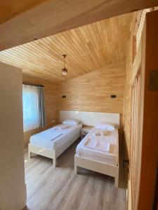 契拉勒普拉节酒店的配有木天花板的客房内的两张床