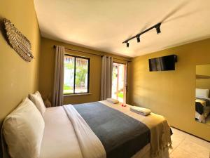 圣路易斯VILA LITORANEA Hotel的卧室配有一张床,墙上配有电视。