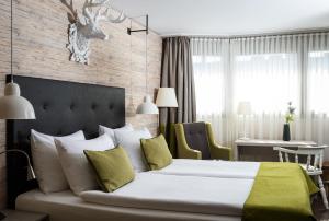 卢塞恩AMERON Luzern Hotel Flora的卧室配有一张白色大床和一张书桌