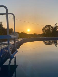 Santa MartaCasa Alfazema do Monte的享有日落背景的游泳池