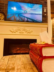 Riyadh Al Khabraبيتي بلس للغرف الفندقية- مدخل مستقل的两本书坐在壁炉前,配有一台电视