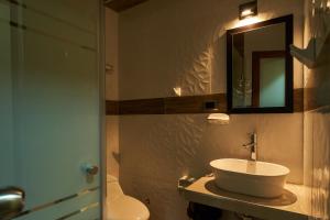 塔尔马Jeranco Hotel的一间带水槽、卫生间和镜子的浴室