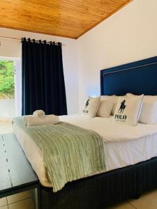 鲁德普特Ouklip Place Hotels的一间卧室配有一张大床和蓝色床头板