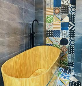 胡志明市Secret Elm Hotel的浴室设有木浴缸,铺着瓷砖