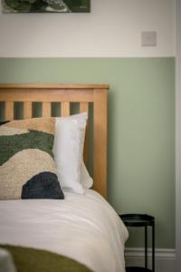 凯特林Vale House By EDEN Accommodation - 2 Bedroom Whole House, Sleeps 4 - NEWLY RENOVATED的一张带木制床头板和白色枕头的床