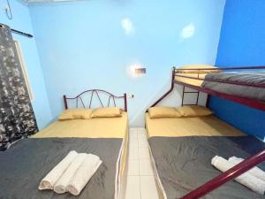 刁曼岛Memory Lane Tioman的蓝色墙壁的客房内设有两张双层床。