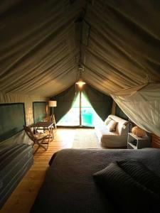 圣路易斯Eco Glamping Portugal Nature Lodge的带帐篷、床和桌子的客房