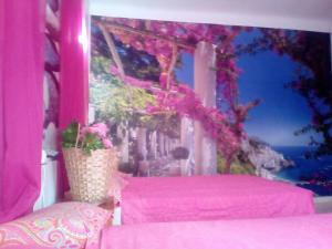 卡拉菲格拉Santiago Mallorca的一间设有粉红色床铺和鲜花窗户的客房