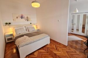 塞尼Vlatkovićeva Apartments的一间卧室配有一张床,铺有木地板