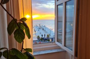塞尼Vlatkovićeva Apartments的享有日落海滩景致的窗户