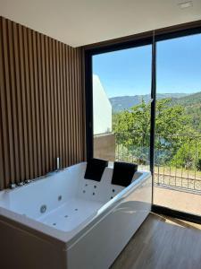 维埃拉·多米尼奥DOBAU village的大型窗户客房内的白色大浴缸