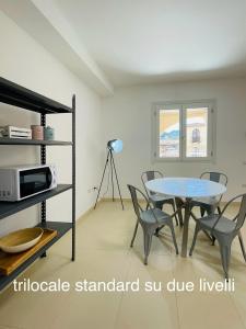 维拉西米乌斯Appartamenti Shardana的一间带桌椅和微波炉的用餐室