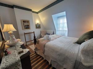 皮克图The Scotsman Inn的一间卧室配有两张床和一张带台灯的桌子
