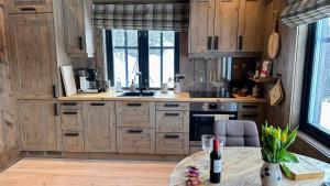 贝特斯托尔Liaplassen Mountain Chalet - Beitostølen的厨房配有木制橱柜和1张带1瓶葡萄酒的桌子。
