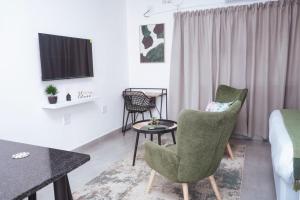 乌姆塔塔Pristine Guest Apartments的一间设有两把椅子、一张桌子和一张床的房间