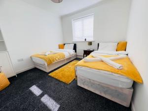 Great BursteadTranquil Haven: 3-BR House的黄色和白色的客房内的两张床