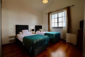 丰沙尔Villa Passion by AnaLodges的一间卧室设有两张床和窗户。